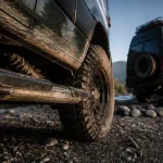 Camping car 4x4 : pneus tout-terrain et garde au sol sur piste boueuse