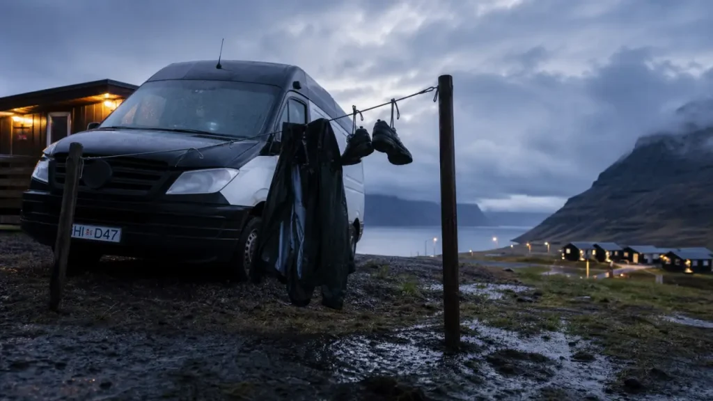Camping car Islande routard : van noir au camping sous pluie