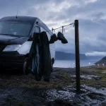 Camping car Islande routard : van noir au camping sous pluie