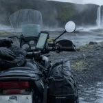 Motorbike road trip en Islande : moto sur route côtière, gravier mouillé et pluie