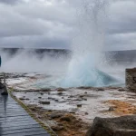 geyser islande Strokkur en éruption, vapeur et voyageurs sur le Cercle d’Or